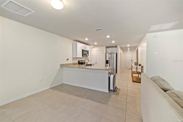 24748 Rio Villa Lakes Cir, Punta Gorda, FL 33950 - kitchen featuring appliances with stainless steel finishes, a peninsula, open floor plan, light tile patterned flooring, and light stone countertops