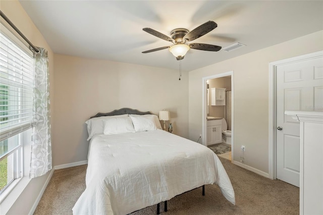 24748 Rio Villa Lakes Cir, Punta Gorda, FL 33950 - bedroom featuring multiple windows, light colored carpet, and connected bathroom