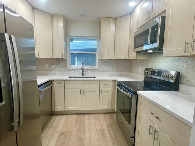 6300 Flotilla Dr Unit 71, Holmes Beach, FL 34217 - kitchen featuring stainless steel appliances, light wood-style floors, backsplash, and light countertops