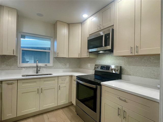 6300 Flotilla Dr Unit 71, Holmes Beach, FL 34217 - kitchen with stainless steel appliances, light wood-style flooring, light countertops, and backsplash