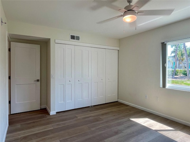 6300 Flotilla Dr Unit 71, Holmes Beach, FL 34217 - unfurnished bedroom with multiple windows, wood finished floors, a closet, and a ceiling fan