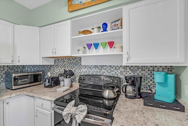 201 75th St Unit A, Holmes Beach, FL 34217 - kitchen featuring black range with electric stovetop, open shelves, stainless steel microwave, and white cabinets