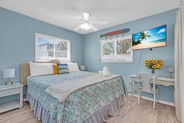 201 75th St Unit A, Holmes Beach, FL 34217 - bedroom with wood finished floors, multiple windows, and a ceiling fan