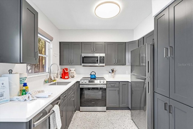 201 75th St Unit A, Holmes Beach, FL 34217 - kitchen featuring appliances with stainless steel finishes, light countertops, gray cabinets, and dark aggregate flooring