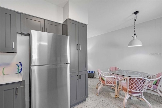 201 75th St Unit A, Holmes Beach, FL 34217 - kitchen featuring freestanding refrigerator, gray cabinets, dark speckled floor, pendant lighting, and light countertops