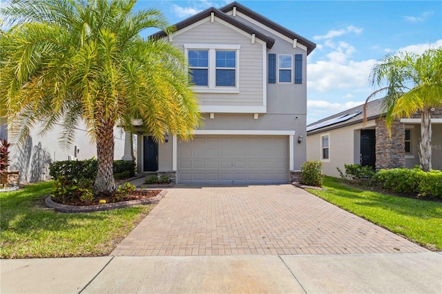 9629 Ivory Dr, Ruskin, FL 33573 - view of front facade with decorative driveway, stucco siding, a garage, and a front yard