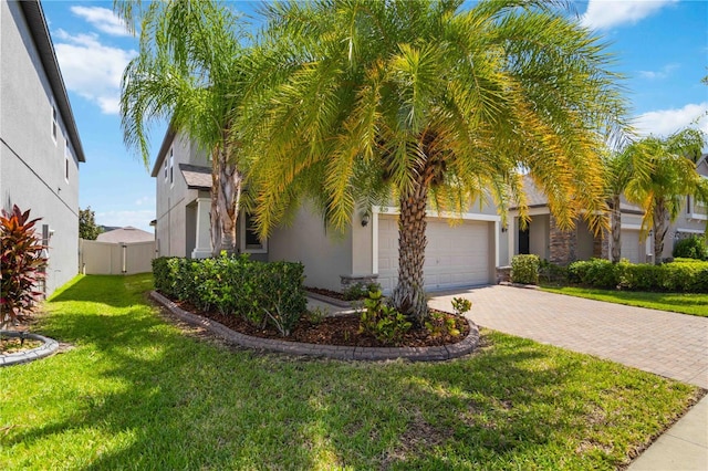9629 Ivory Dr, Ruskin, FL 33573 - obstructed view of property with a garage, stucco siding, decorative driveway, and stone siding