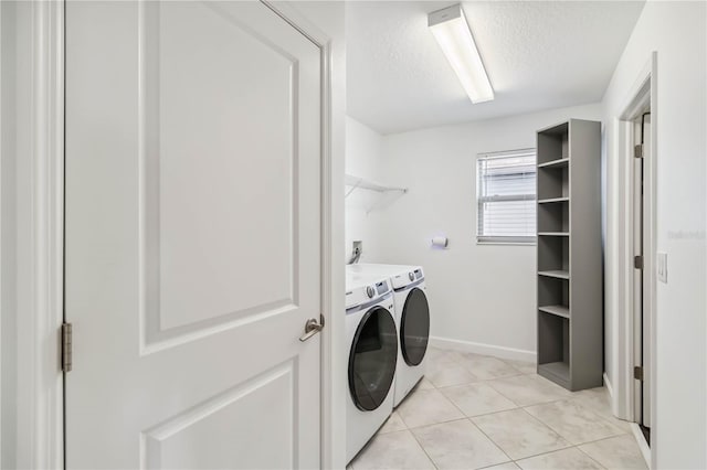 9629 Ivory Dr, Ruskin, FL 33573 - laundry room with washing machine and dryer, a textured ceiling, and light tile patterned floors