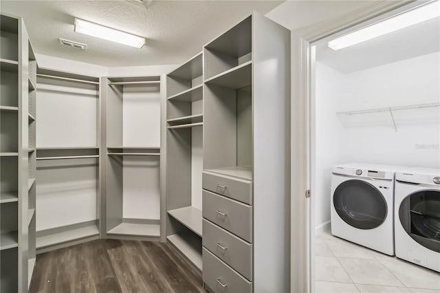 9629 Ivory Dr, Ruskin, FL 33573 - laundry room with washer and clothes dryer, wood finished floors, and a textured ceiling