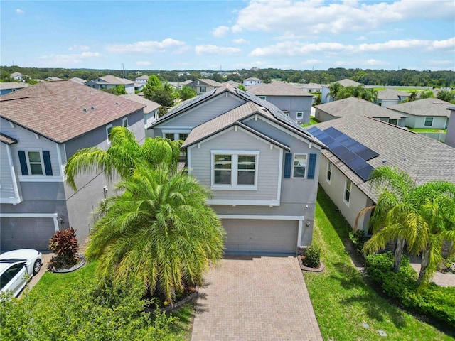 9629 Ivory Dr, Ruskin, FL 33573 - view of front of house featuring decorative driveway, a residential view, a garage, stucco siding, and a front yard