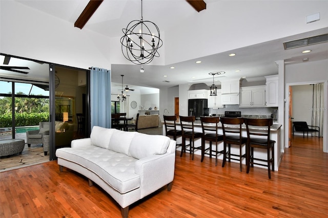 355 Trieste Dr, Punta Gorda, FL 33950 - living room featuring a chandelier, a high ceiling, light wood-type flooring, recessed lighting, and beam ceiling