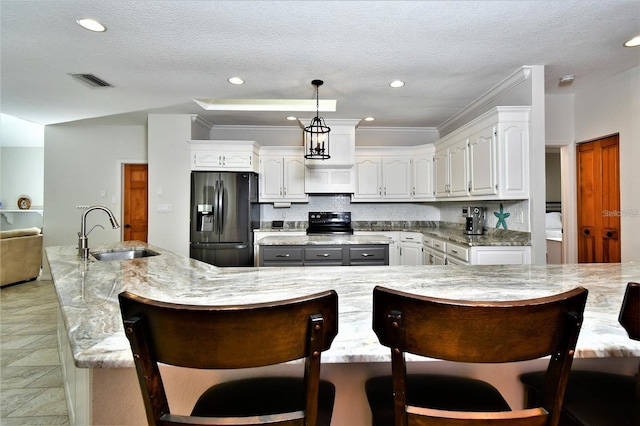 355 Trieste Dr, Punta Gorda, FL 33950 - kitchen featuring refrigerator with ice dispenser, a large island, electric range, white cabinetry, and decorative backsplash