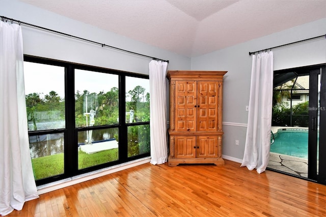 355 Trieste Dr, Punta Gorda, FL 33950 - empty room with light wood-style floors, a water view, and a textured ceiling