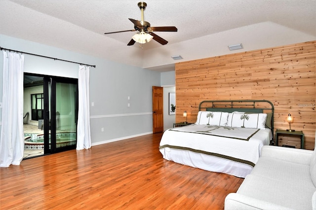 355 Trieste Dr, Punta Gorda, FL 33950 - bedroom featuring wood finished floors, access to exterior, a textured ceiling, wood walls, and lofted ceiling