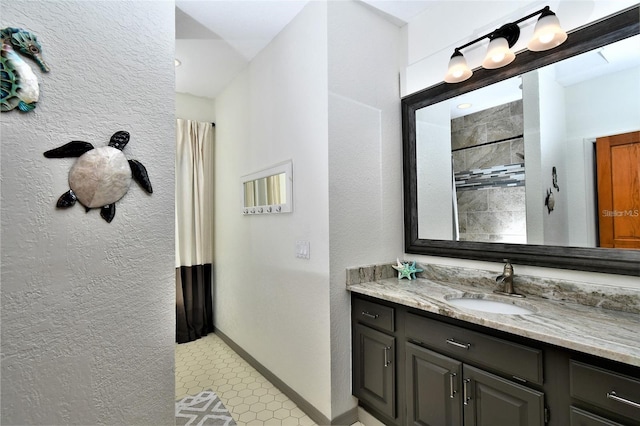 355 Trieste Dr, Punta Gorda, FL 33950 - bathroom with tiled shower, vanity, and a textured wall