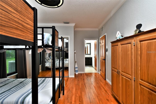 355 Trieste Dr, Punta Gorda, FL 33950 - bedroom with a textured ceiling, light wood finished floors, crown molding, and a textured wall