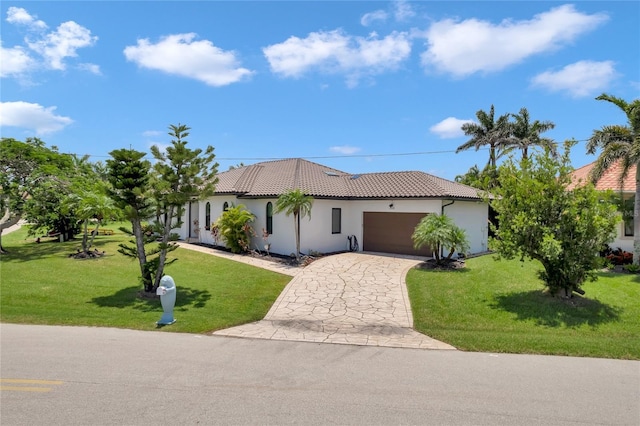 355 Trieste Dr, Punta Gorda, FL 33950 - view of front facade featuring stucco siding, a garage, driveway, a tile roof, and a front lawn