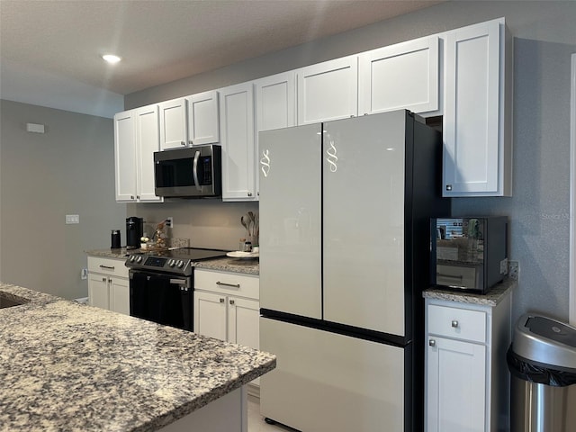 6 Pine Bluff Ln, Palm Coast, FL 32164 - kitchen with appliances with stainless steel finishes, white cabinetry, and stone countertops