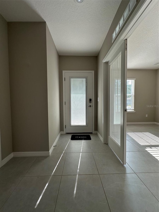 6 Pine Bluff Ln, Palm Coast, FL 32164 - doorway to outside with tile patterned floors and a textured ceiling