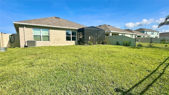 12293 Mountain Island Trl, Parrish, FL 34219 - rear view of property with a fenced backyard, stucco siding, glass enclosure, and roof with shingles