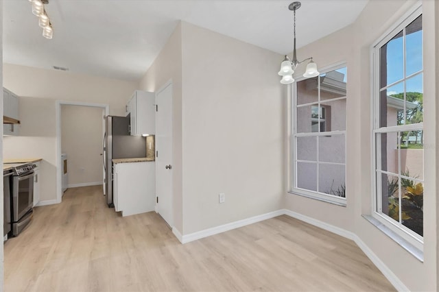 4050 Pinebrook Cir Unit 5, Bradenton, FL 34209 - unfurnished dining area featuring light wood-style floors, a chandelier, and washer / clothes dryer