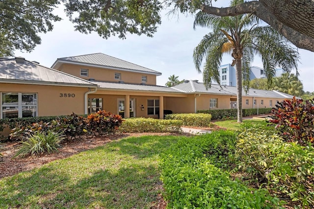 4050 Pinebrook Cir Unit 5, Bradenton, FL 34209 - back of property featuring stucco siding, a standing seam roof, a metal roof, and a yard