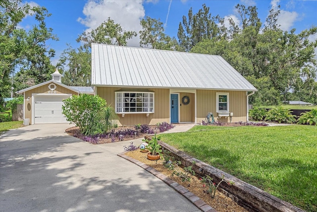 626 Hand Ave, Sarasota, FL 34232 - view of front facade with driveway, a front yard, a metal roof, and a garage