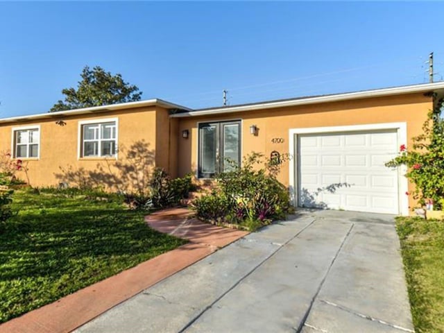 4700 Mineola St, Bradenton, FL 34207 - single story home with stucco siding, driveway, a garage, and a front yard