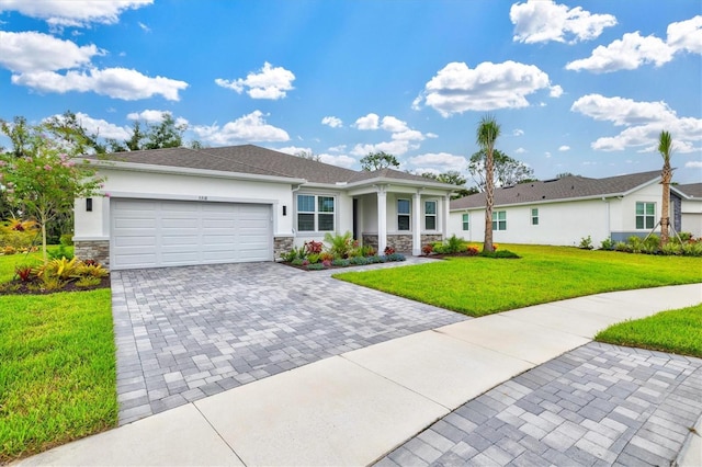 5318 124th Ave E, Parrish, FL 34219 - view of front of property with stone siding, stucco siding, a garage, a front yard, and decorative driveway