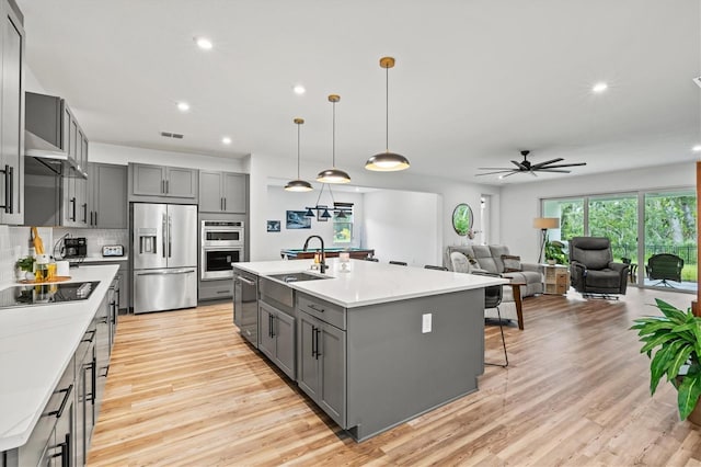 5318 124th Ave E, Parrish, FL 34219 - kitchen with gray cabinetry, appliances with stainless steel finishes, light countertops, recessed lighting, and light wood-style floors