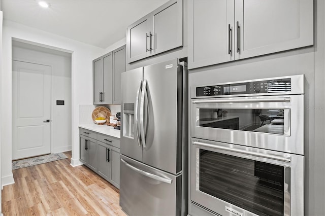 5318 124th Ave E, Parrish, FL 34219 - kitchen with gray cabinets, appliances with stainless steel finishes, light wood-type flooring, and light countertops