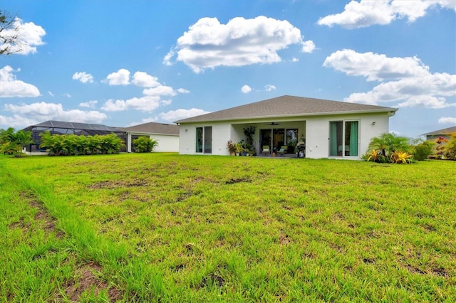 5318 124th Ave E, Parrish, FL 34219 - back of house featuring ceiling fan, a lawn, and stucco siding