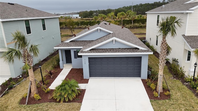 9084 Tequila Sunrise Dr, Sarasota, FL 34241 - view of front facade featuring a shingled roof, concrete driveway, an attached garage, and stucco siding