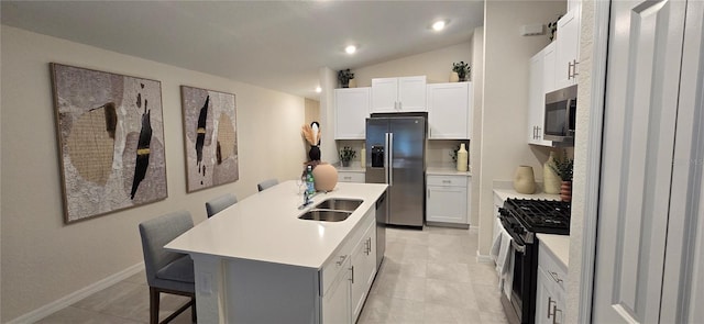 9084 Tequila Sunrise Dr, Sarasota, FL 34241 - kitchen with appliances with stainless steel finishes, a breakfast bar, light countertops, white cabinetry, and a kitchen island with sink