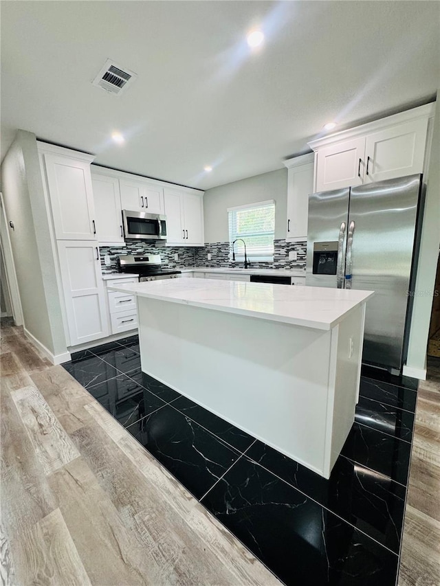 7013 Symmes Rd, Gibsonton, FL 33534 - kitchen featuring appliances with stainless steel finishes, recessed lighting, tasteful backsplash, and white cabinetry
