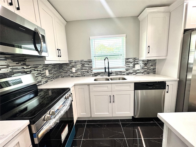 7013 Symmes Rd, Gibsonton, FL 33534 - kitchen featuring appliances with stainless steel finishes, dark marble finish floors, white cabinets, and light countertops