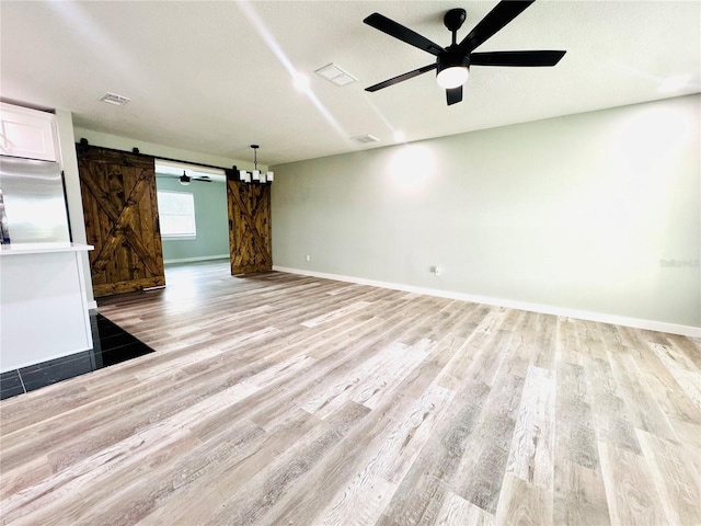 7013 Symmes Rd, Gibsonton, FL 33534 - empty room featuring a barn door, light wood-style floors, and ceiling fan