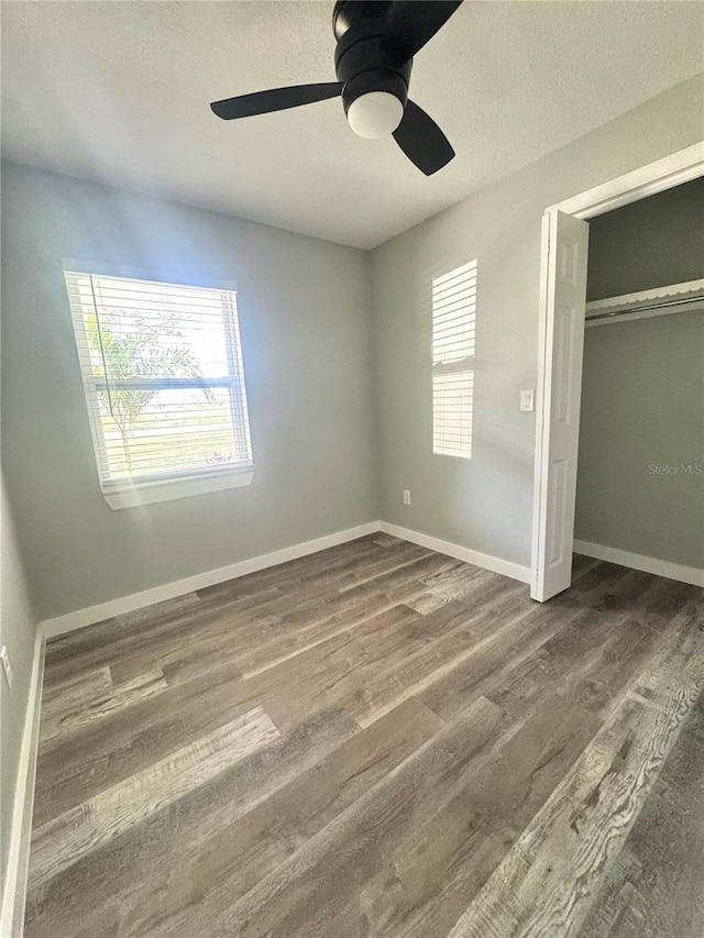 7013 Symmes Rd, Gibsonton, FL 33534 - unfurnished bedroom with wood finished floors, a ceiling fan, a closet, and a textured ceiling