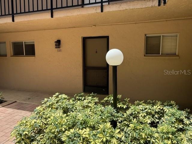 2763 Woodgate Ln Unit 111, Sarasota, FL 34231 - doorway to property featuring stucco siding