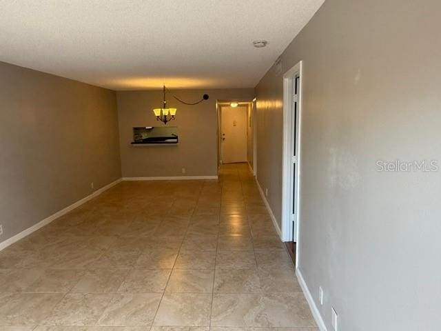 2763 Woodgate Ln Unit 111, Sarasota, FL 34231 - spare room featuring a chandelier and light tile patterned floors