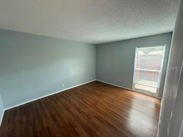 2763 Woodgate Ln Unit 111, Sarasota, FL 34231 - spare room with wood finished floors and a textured ceiling