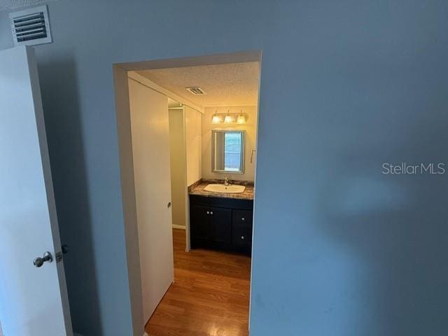 2763 Woodgate Ln Unit 111, Sarasota, FL 34231 - corridor with wood finished floors and a sink