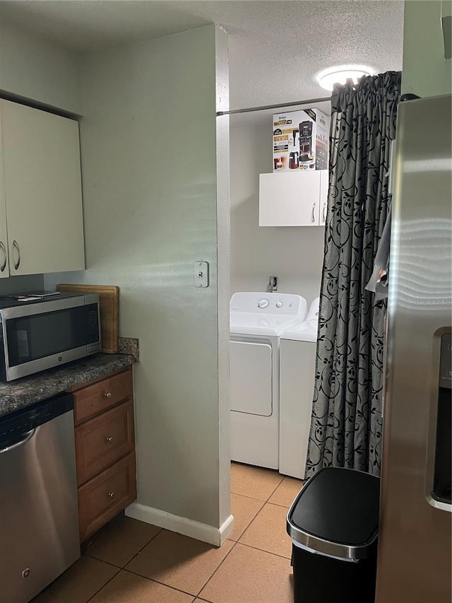 4007 7th St E, Bradenton, FL 34208 - washroom featuring washer and clothes dryer, light tile patterned flooring, cabinet space, and a textured ceiling