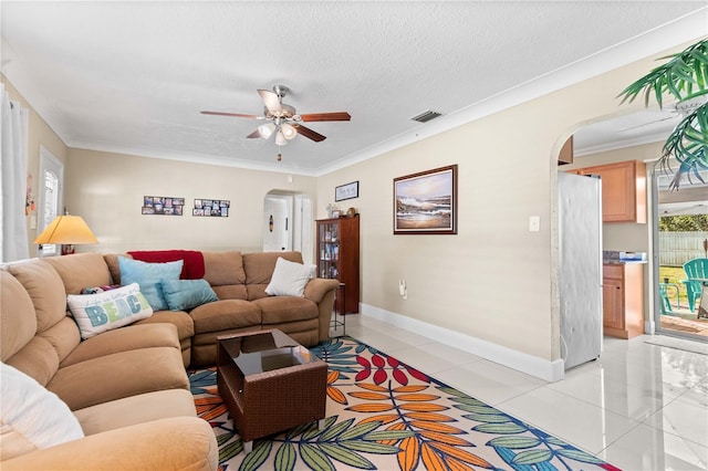 2108 Outer Dr, Sarasota, FL 34231 - living room with arched walkways, ceiling fan, light tile patterned flooring, ornamental molding, and a textured ceiling