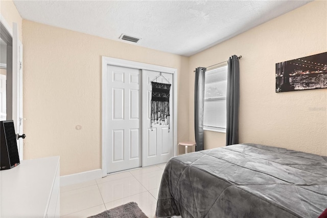 2108 Outer Dr, Sarasota, FL 34231 - bedroom featuring light tile patterned floors, a closet, and a textured ceiling