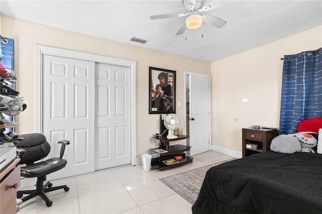 2108 Outer Dr, Sarasota, FL 34231 - tiled bedroom featuring a closet, a ceiling fan, and a textured ceiling