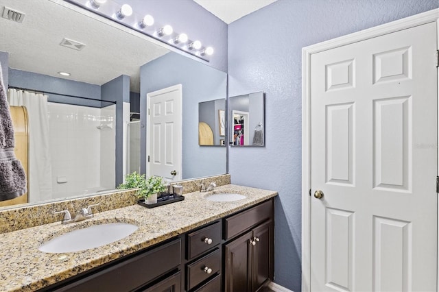 2419 29th Ave E, Palmetto, FL 34221 - bathroom featuring double vanity, a textured wall, and a shower with curtain
