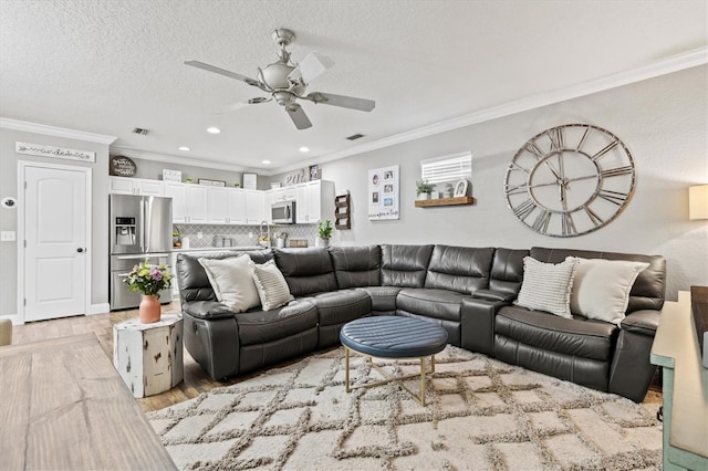 2419 29th Ave E, Palmetto, FL 34221 - living area with crown molding, a ceiling fan, light wood-style floors, recessed lighting, and a textured ceiling