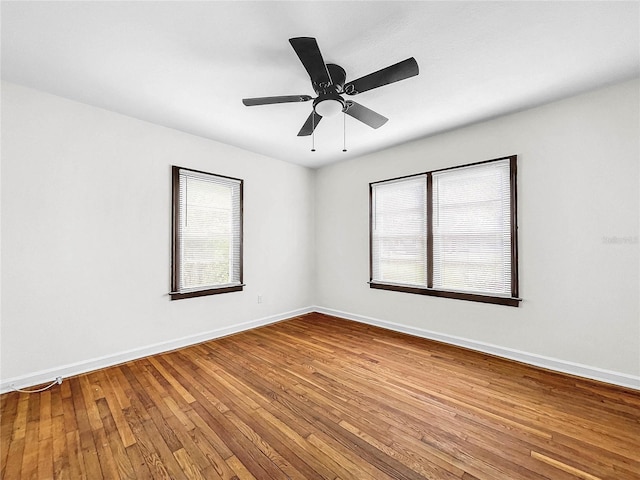 spare room featuring ceiling fan, plenty of natural light, and wood-type flooring