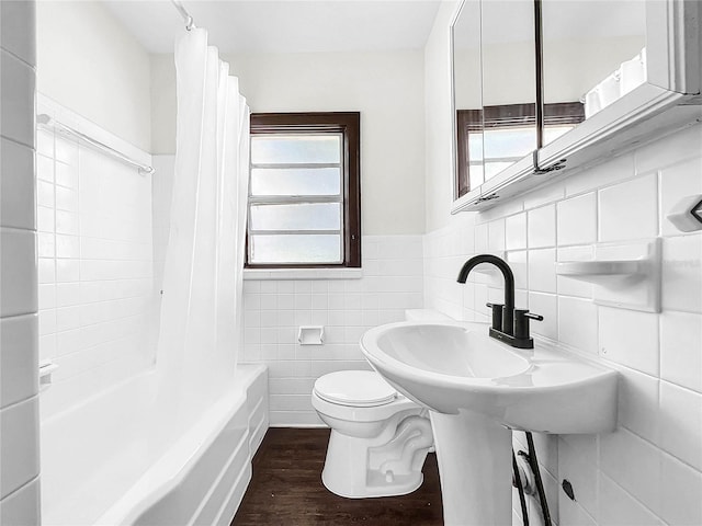 bathroom with toilet, tasteful backsplash, shower / bathtub combination with curtain, wood-type flooring, and tile walls